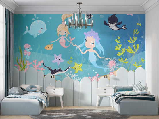 Cartoon mermaids swimming with a black and white orca wall mural.