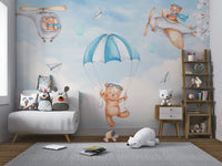 Nursery wall mural featuring a teddy bear in a helicopter with pink blossoms.