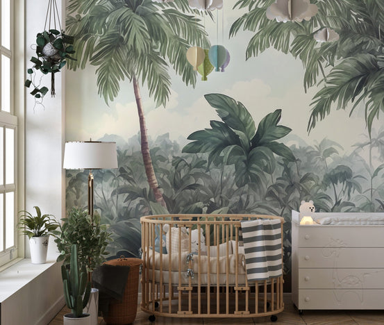 Lush palm tree wall mural in nursery with wooden crib and white dresser.