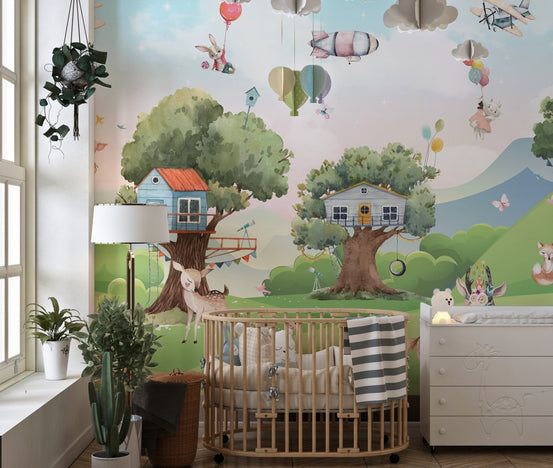 Nursery room with a wooden crib against a cartoon treehouse wall mural.
