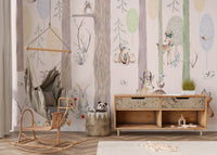 Forest wall mural featuring foxes and squirrels behind a wooden toy chest in nursery.