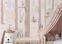 Nursery wall mural with soft pink and green forest next to a pink bed canopy.