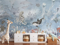 Underwater sea creatures wall mural in soft blue watercolor wallpaper.