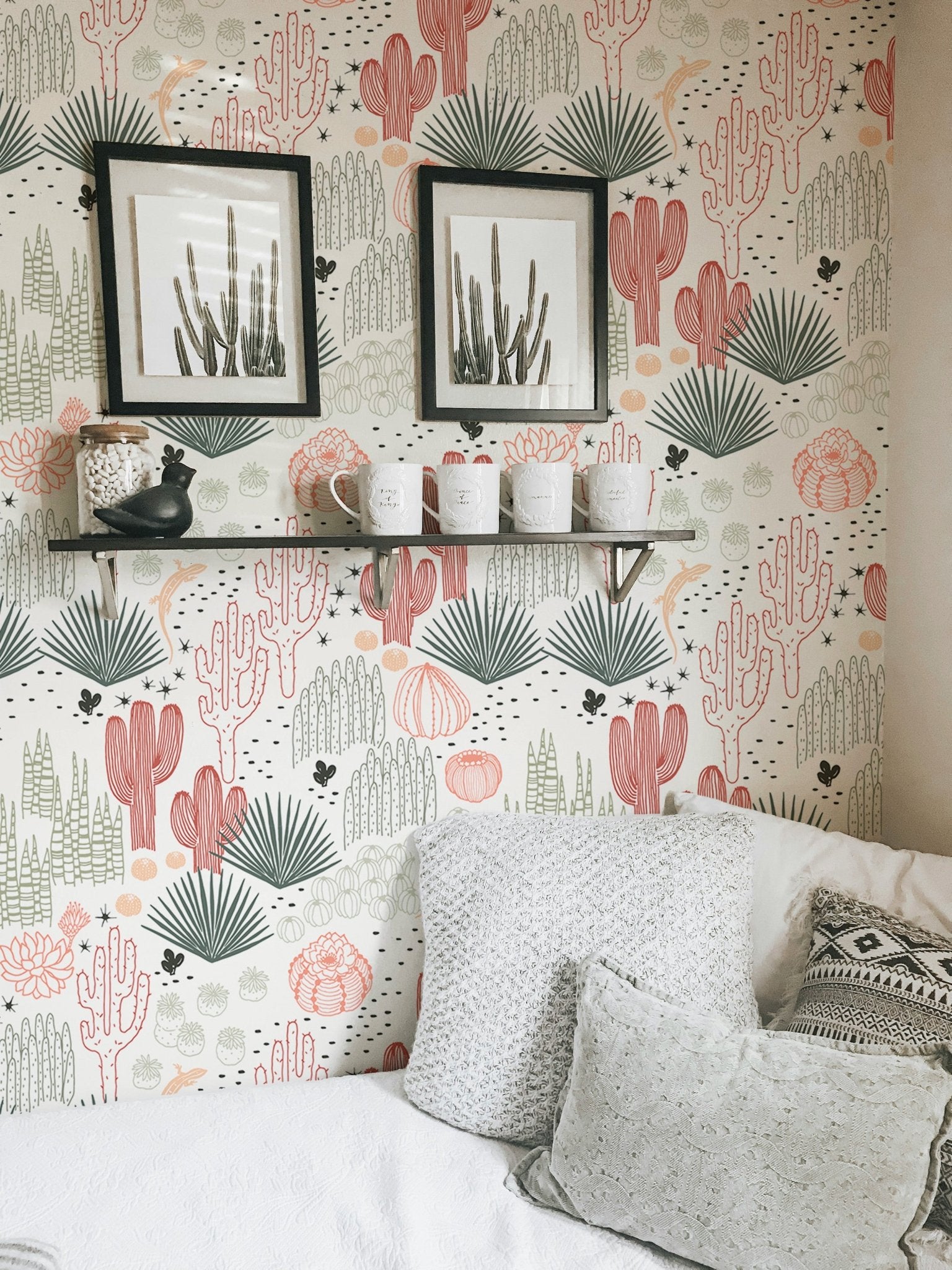 Succulent and lizard pattern wallpaper behind a white sofa with grey cushions.