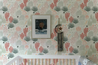 Wallpaper with cacti and lizards above a white crib in a bright nursery.