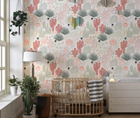 Nursery room with a wooden crib and desert succulents wallpaper.