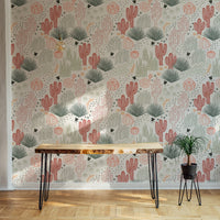 Minimalist desk area with Mexican cacti wallpaper and a small green plant.