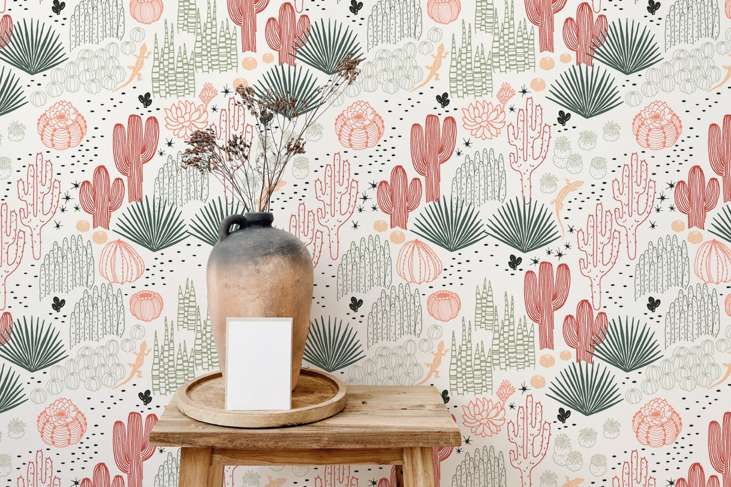 Tabletop decor against a background of pink and green succulent wallpaper.