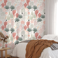 Desert landscape wallpaper in a bedroom featuring white bedding and a brown shawl.