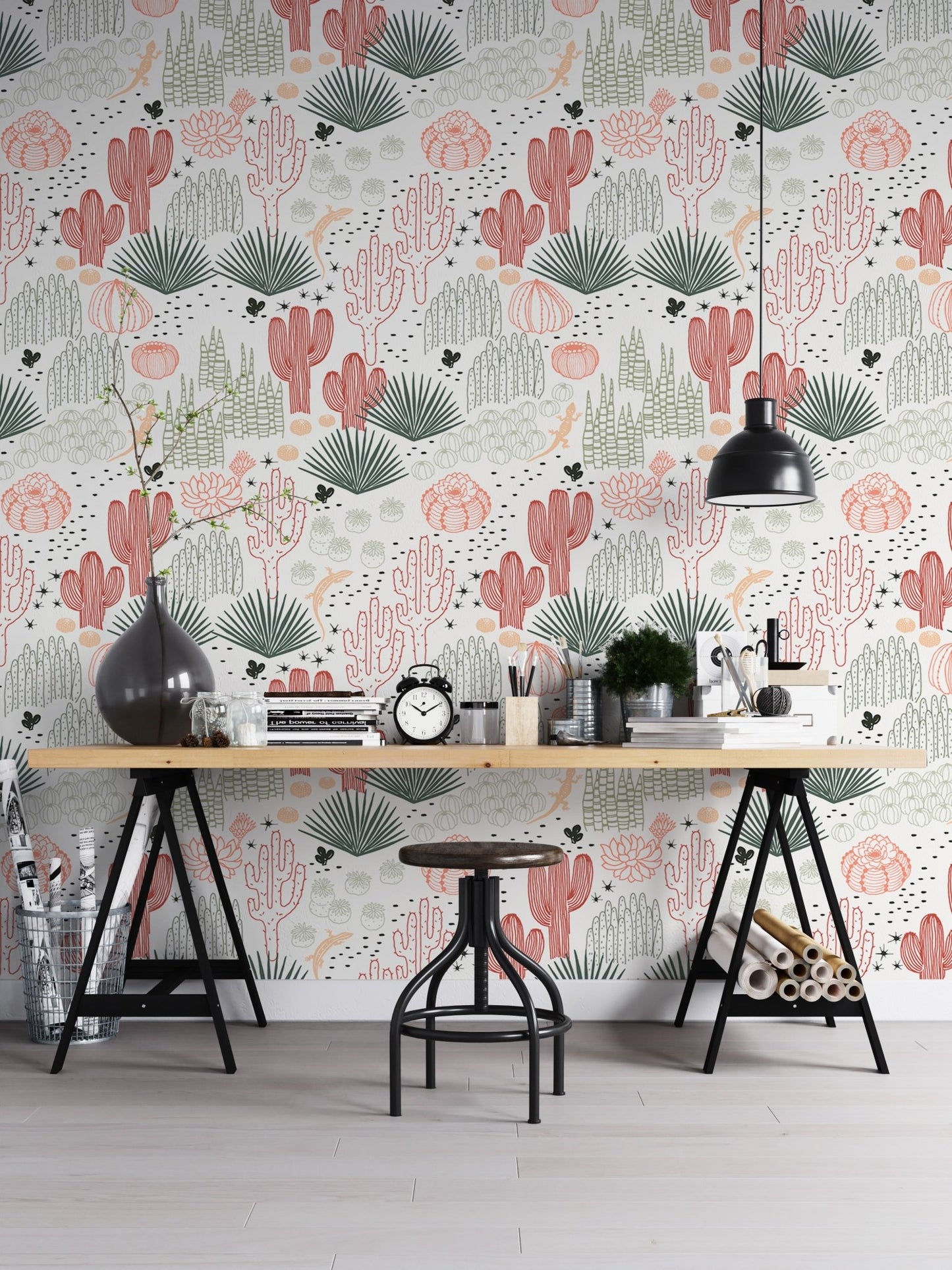 Succulent wallpaper behind a wooden desk and black industrial lamps in a workspace.