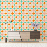 Multi-colored diamond wall mural behind a modern wooden cabinet and purple flowers.