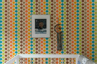 Retro geometric wall mural with orange, teal and brown stripes in a nursery.