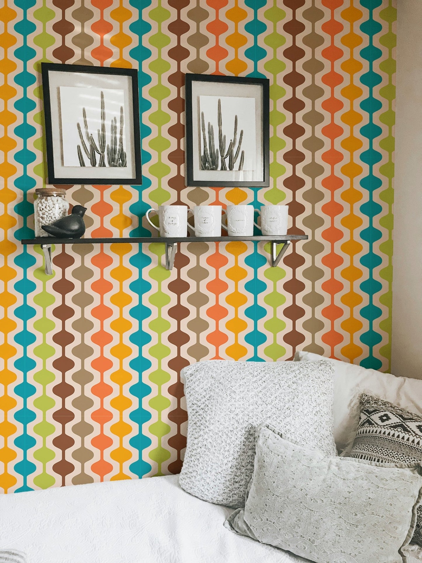 Ogee geometric curve wall mural behind a white sofa and decorative wall frames.