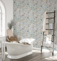 Bathroom featuring a white bathtub and terrazzo wallpaper with a wooden ladder shelf.