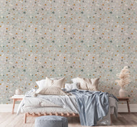 Terrazzo pattern wallpaper behind a large bed with blue and grey cushions.