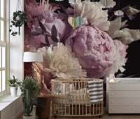 Pink flower garden wall mural in a nursery with a wooden crib and indoor plants.
