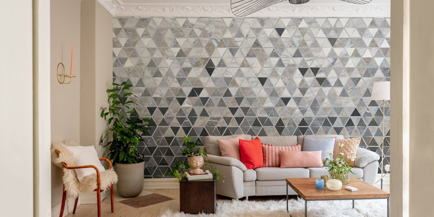 Geometric tiles wall mural in a living room behind a light beige sofa.