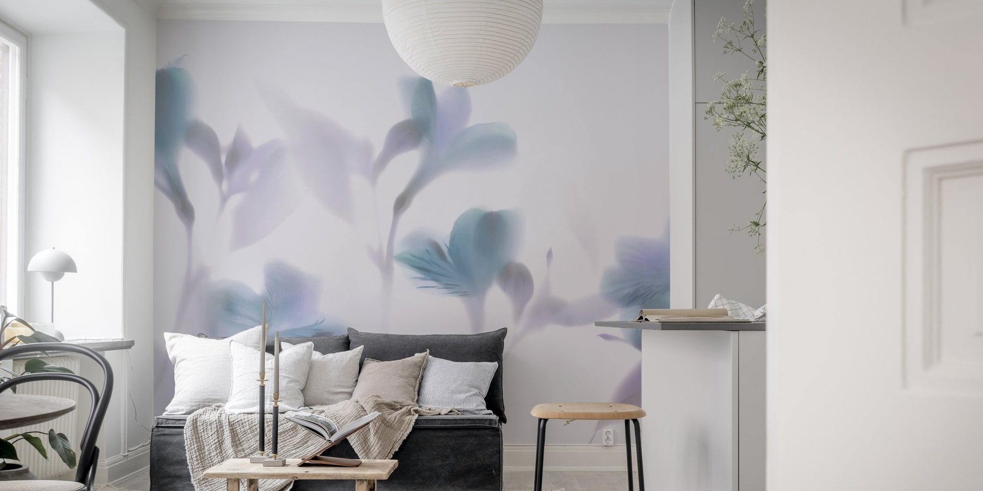 Minimalist living area with blurred orchid pattern wall mural and grey sofa.