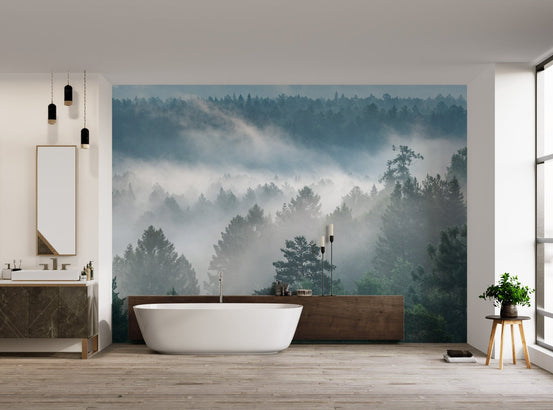 Atmospheric pine tree misty wallpaper with ethereal white clouds drifting through branches.