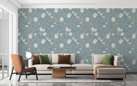 Elegant floral branch wallpaper with soft turquoise background on living room walls.