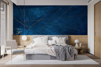 Blue and gold abstract wall mural as a backdrop for a light wood bed set.