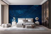 Dark blue abstract wall mural with intersecting gold lines in a contemporary bedroom.