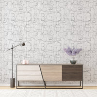 Modern Roman Classic Alphabet Method Geometric Wallpaper behind a tri-tone wooden sideboard.