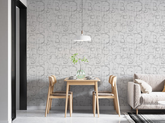 Grey alphabet wallpaper in a dining space with a hanging light fixture.