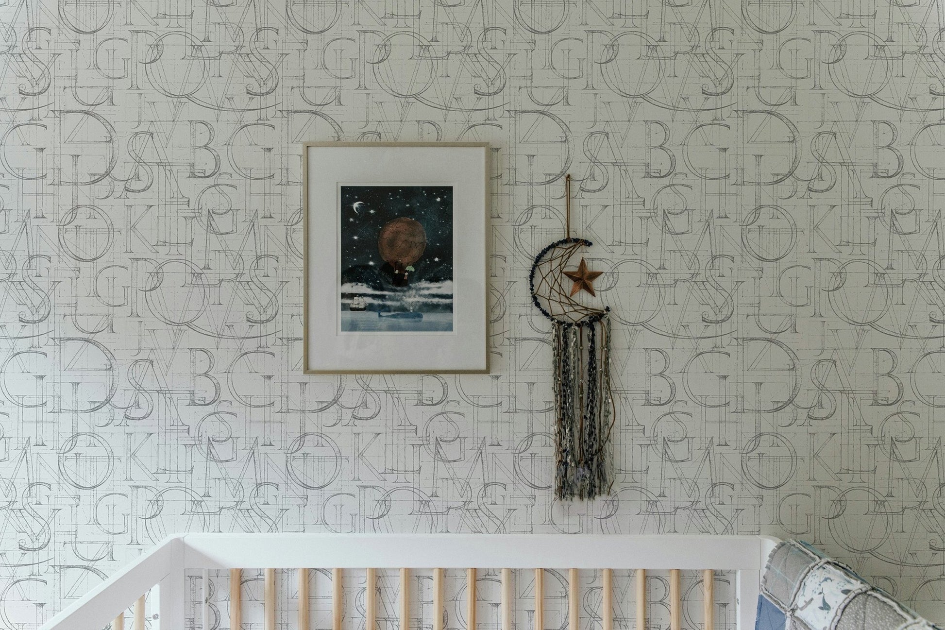 Modern Roman Classic Alphabet Method Geometric Wallpaper in a nursery above a white crib.