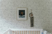 Modern Roman Classic Alphabet Method Geometric Wallpaper in a nursery above a white crib.