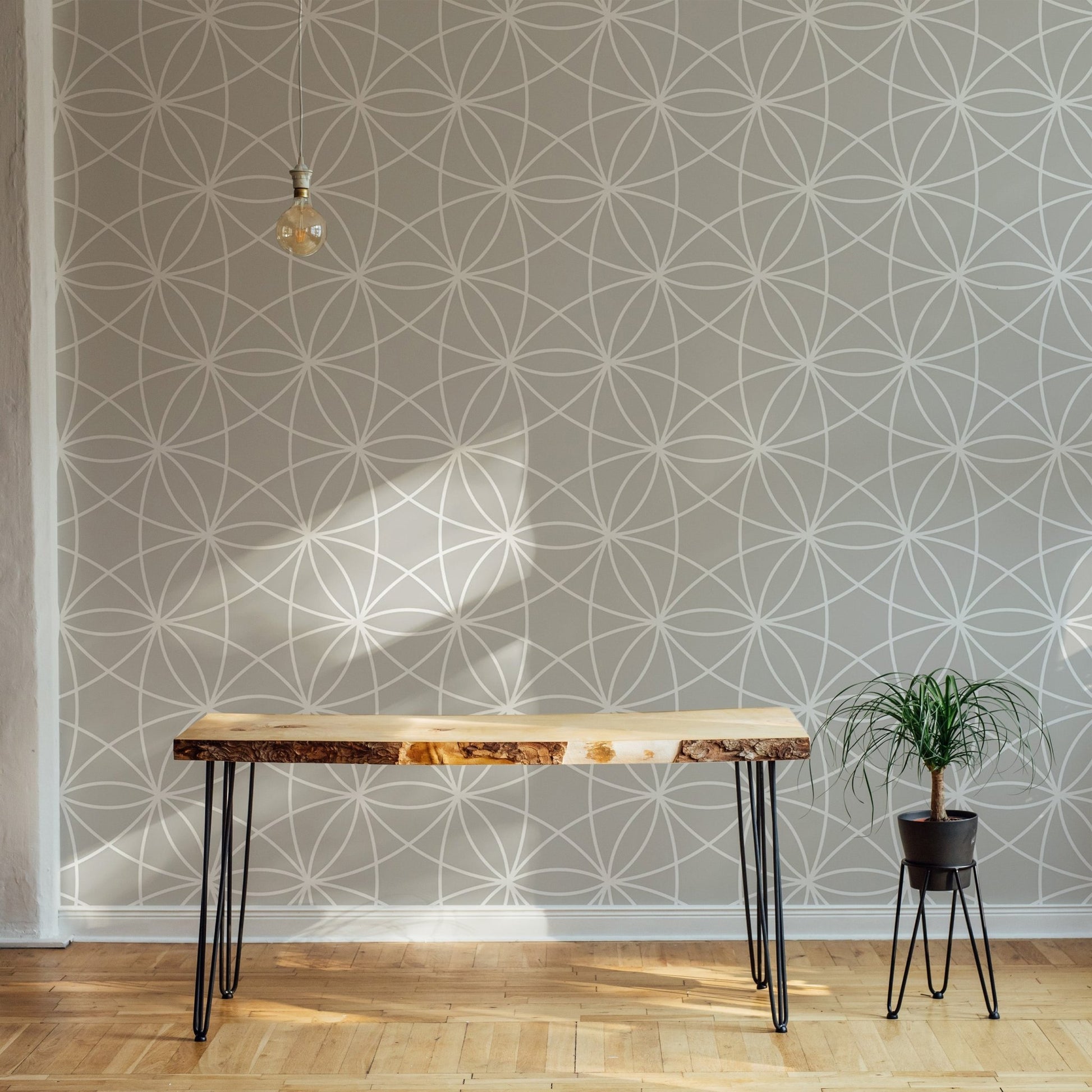 Geometric repeat wallpaper behind a slim wooden console table in a hallway.