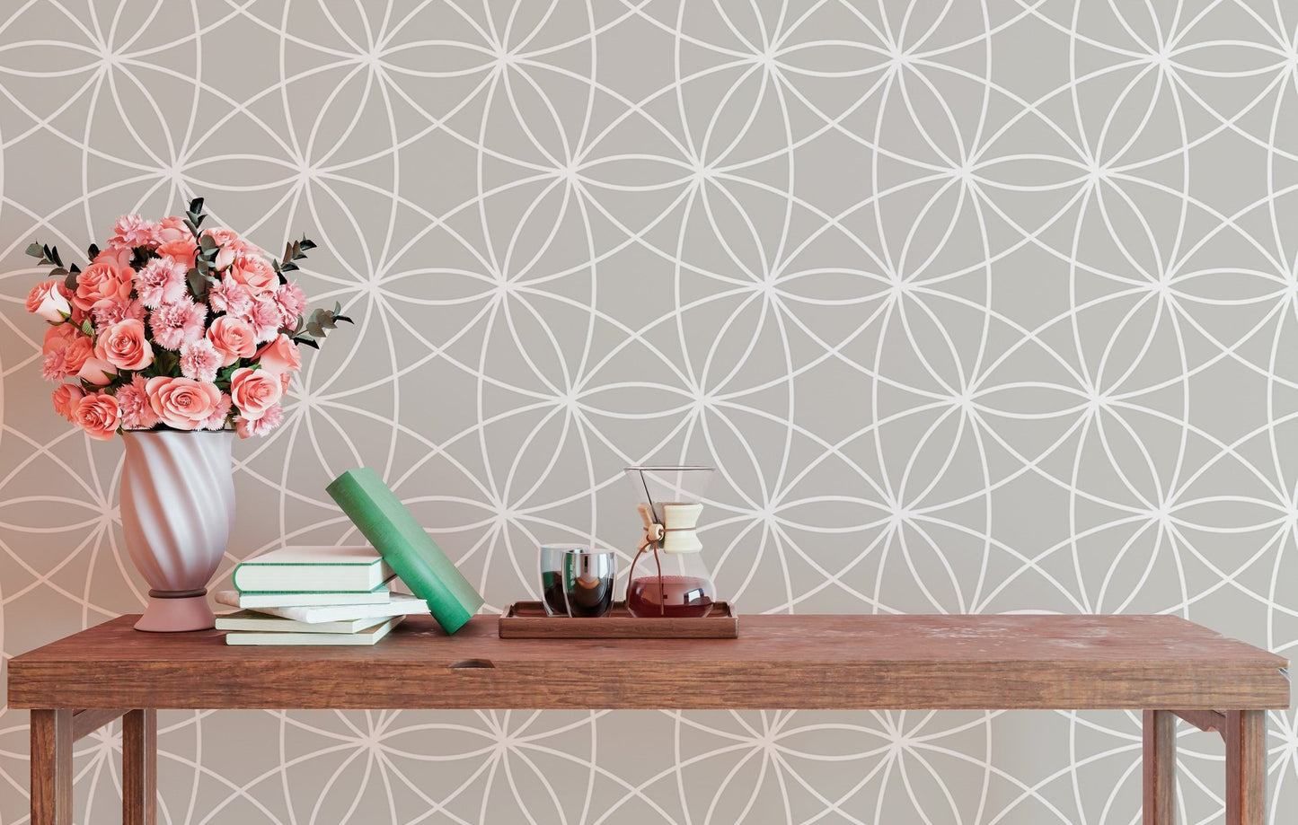Symmetrical line pattern wallpaper behind a wooden bench with pink flowers.
