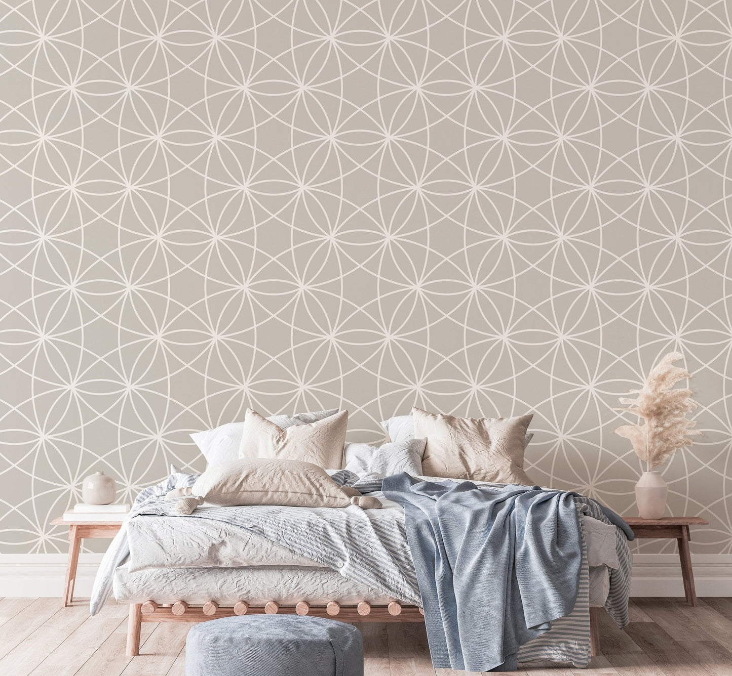 Geometric line wallpaper in a bedroom with blue bedding and pampas grass.