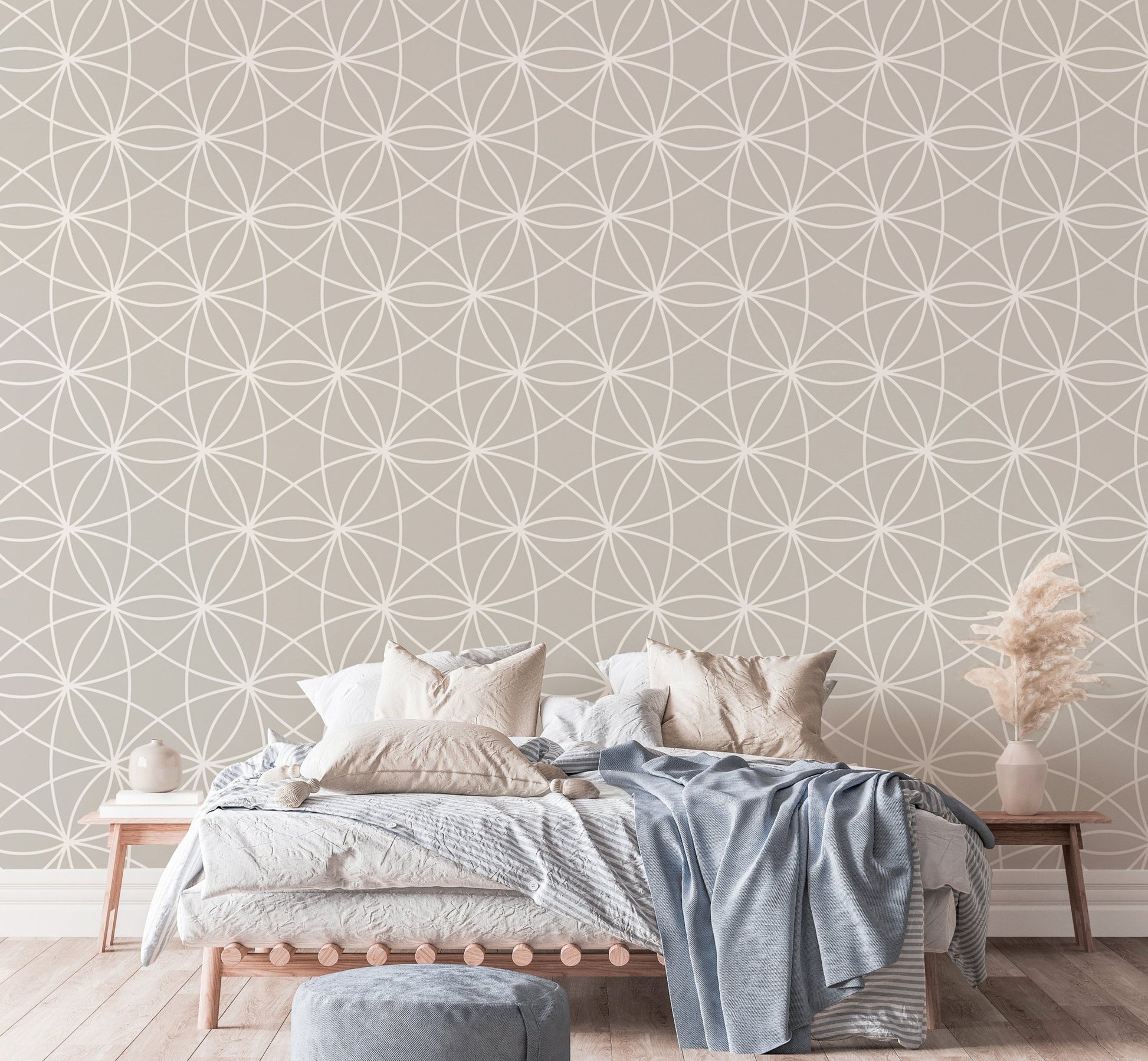 Geometric line wallpaper in a bedroom with blue bedding and pampas grass.