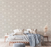 Geometric line wallpaper in a bedroom with blue bedding and pampas grass.