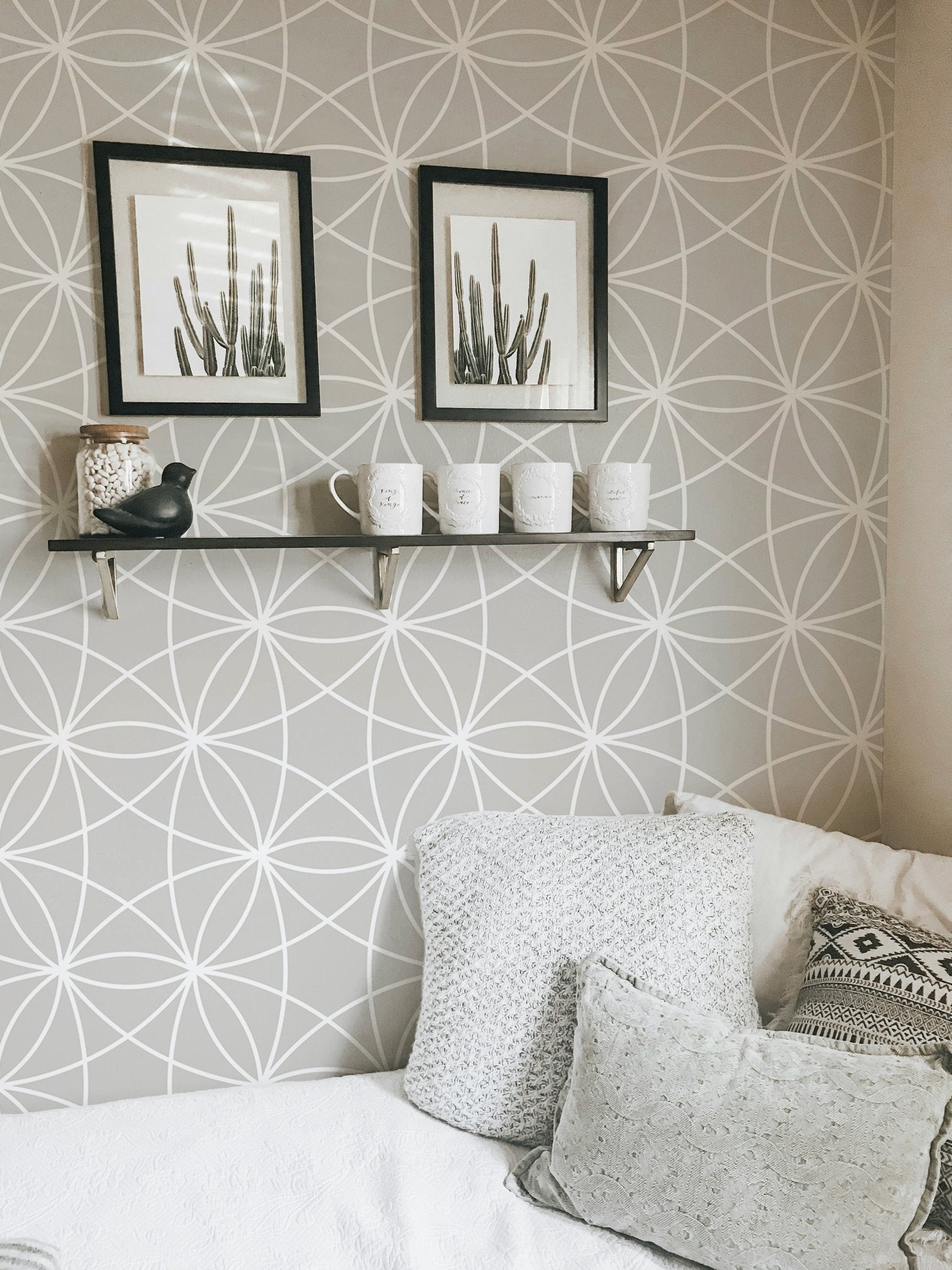 Minimalist line pattern wallpaper in a bedroom featuring white framed art.