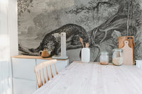 Minimalist dining room with a monochrome leopard wall mural and light wood chairs.