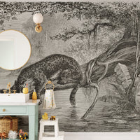 Detailed leopard wall mural behind a mint green vanity and round mirror.