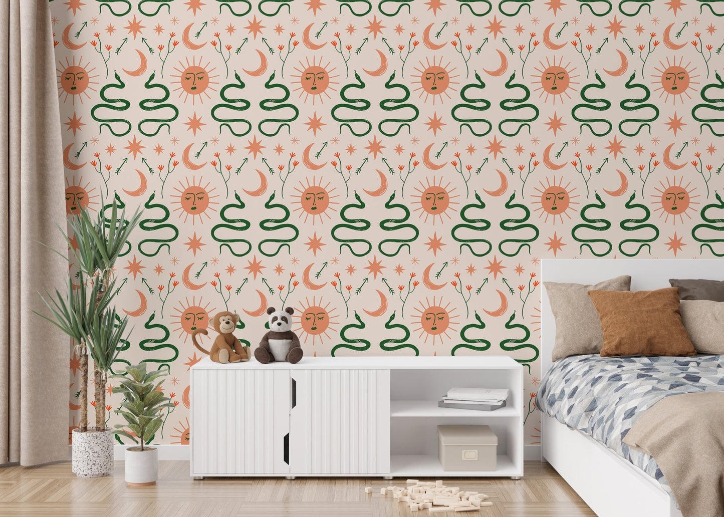 Green snake and orange sun wallpaper in a bedroom behind a white cabinet and bed.