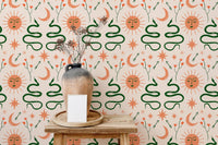Moon and sun Boho wallpaper with snakes design behind wooden table and vase.
