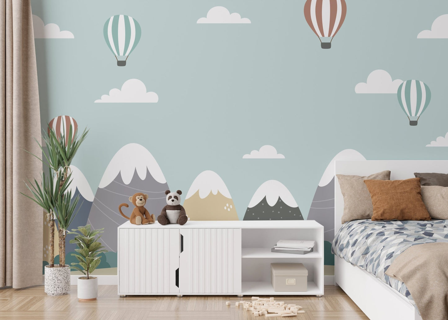 Kids' bedroom with mountain wall mural and white storage cabinets.