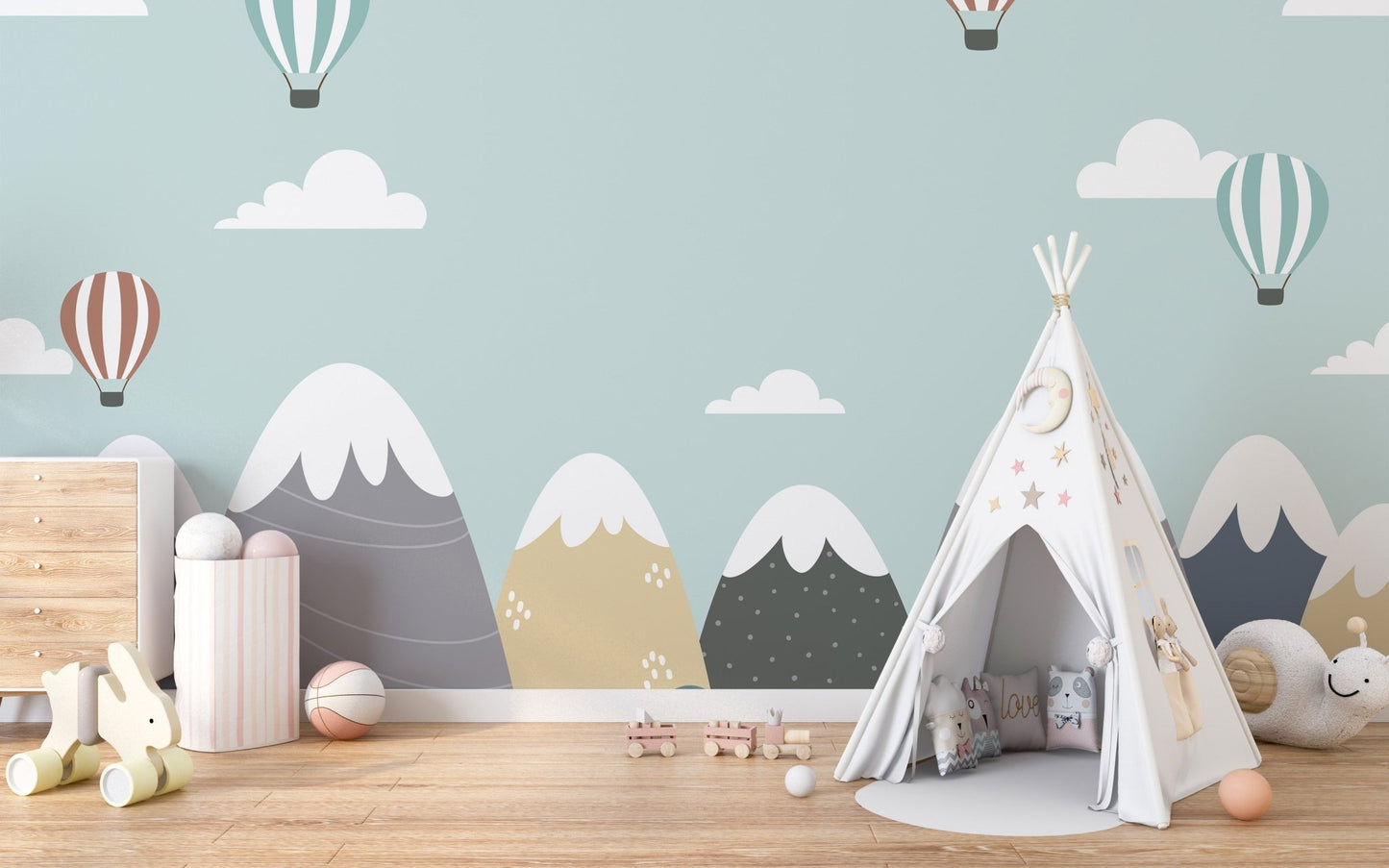 Nursery interior featuring a white teepee tent and mountain wall mural.