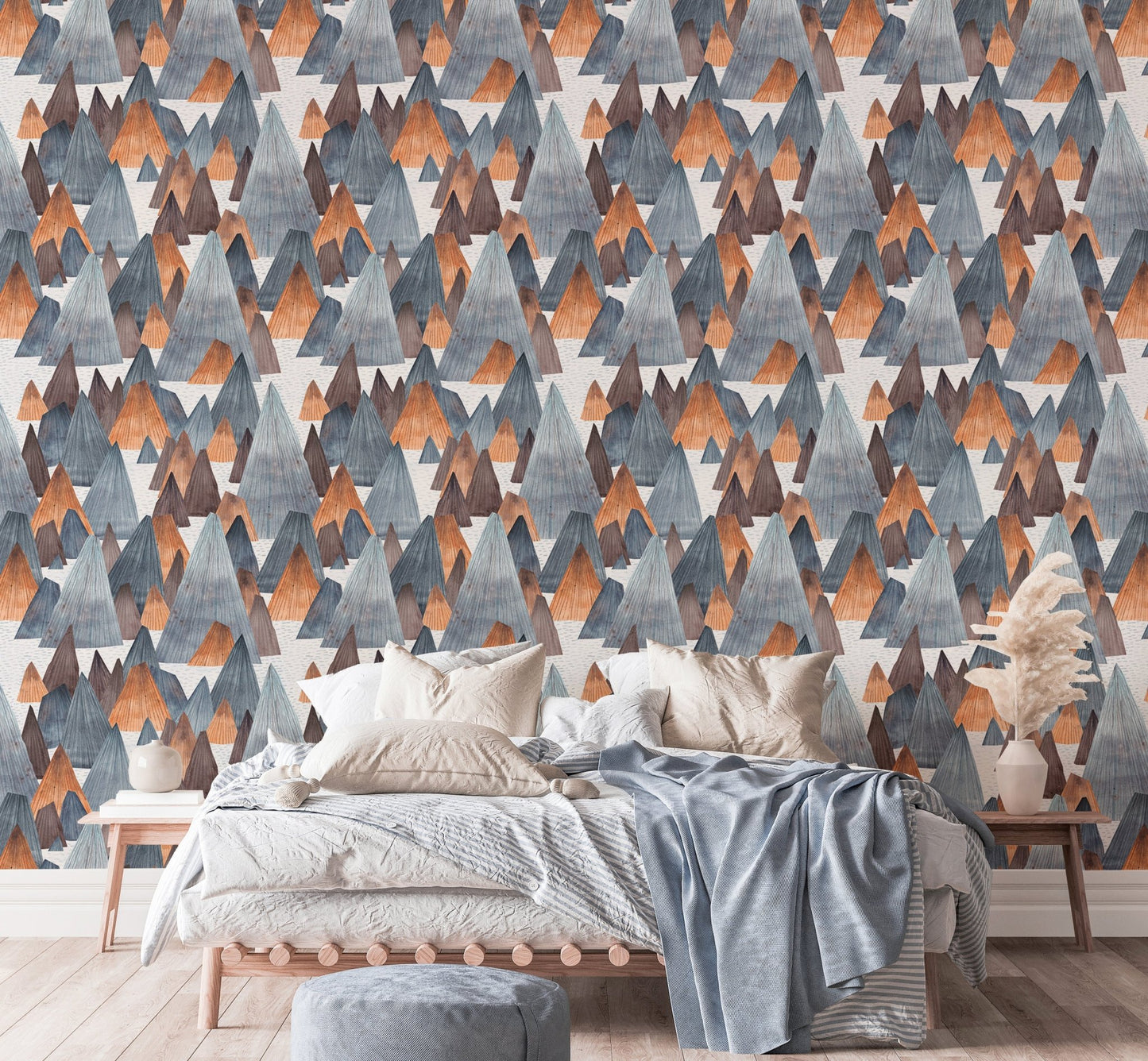 Modern mountain landscape wallpaper behind bed with blue linens.