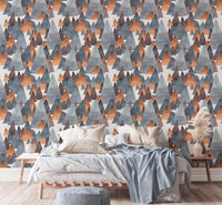 Modern mountain landscape wallpaper behind bed with blue linens.
