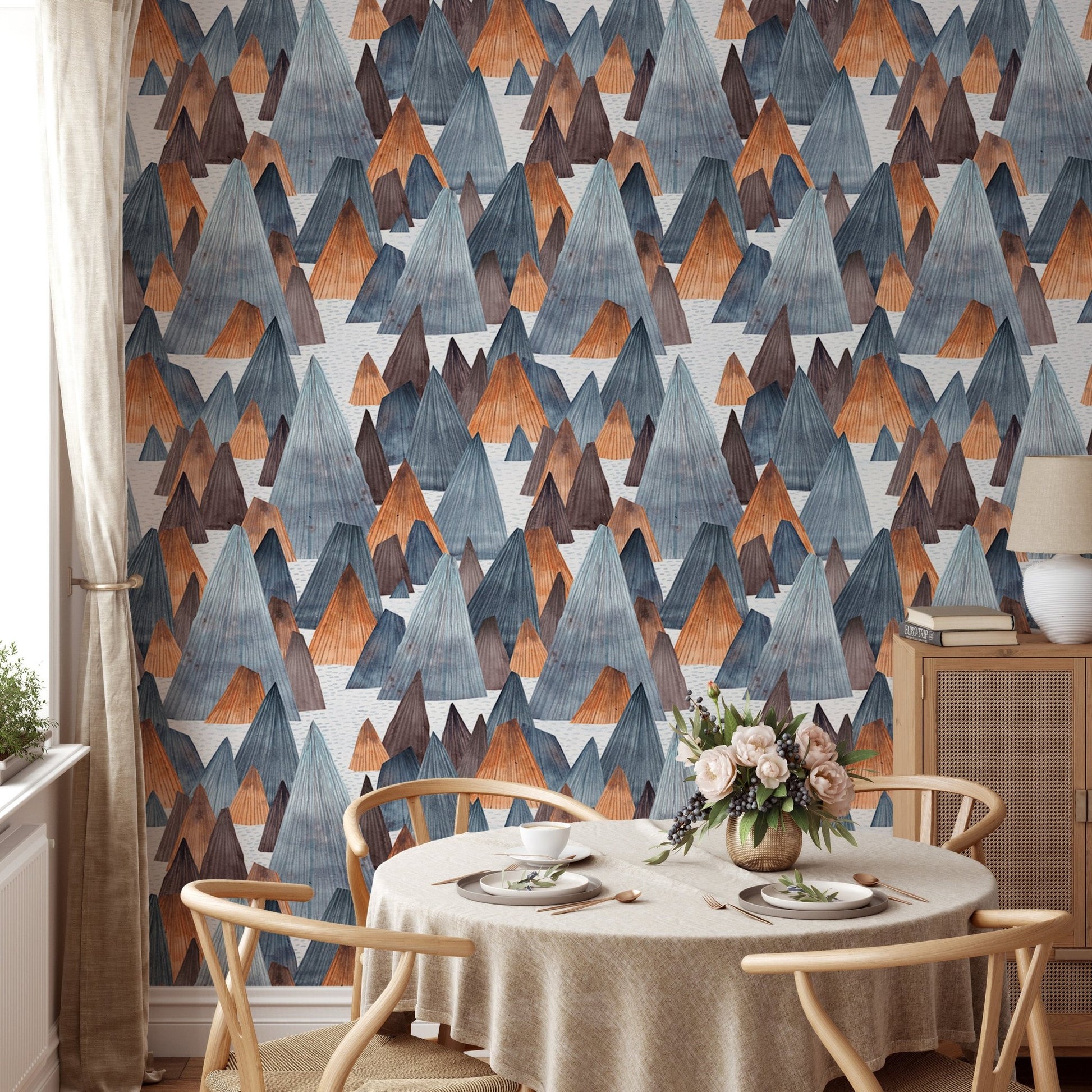 Earth tone mountain wallpaper in dining room with circular table.