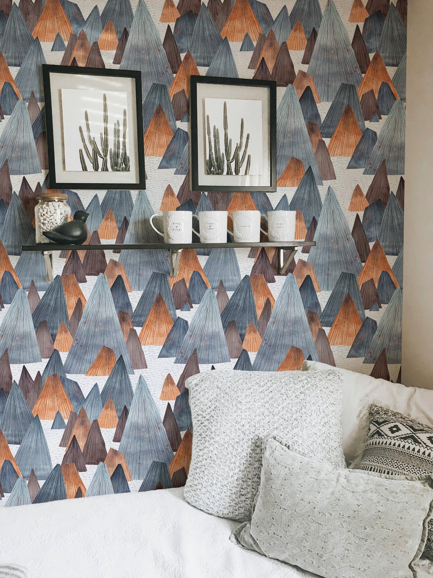 Minimalist mountain wallpaper with black frames and white bedding.