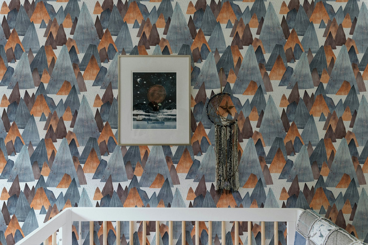 Abstract mountain mural featuring framed art in nursery setting.