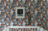 Abstract mountain mural featuring framed art in nursery setting.