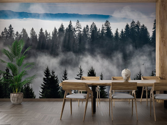 Minimalist dining area with wooden table and misty woodland wall mural.