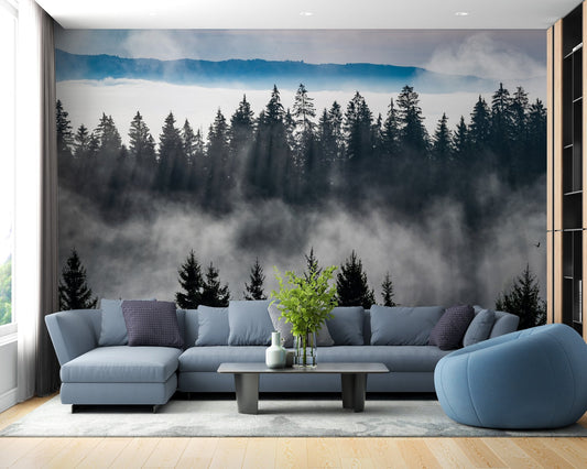Blue sectional sofa against a mountain pine tree wall mural in a bright room.